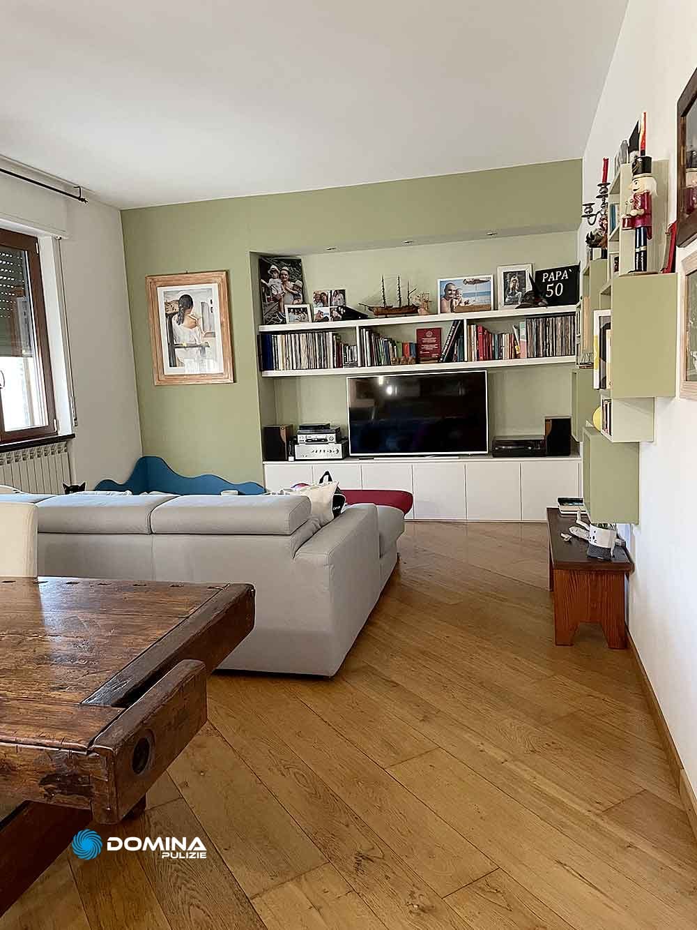 Un soggiorno con pavimento in legno fotografato dopo il servizio di pulizie straordinarie appartamenti di Domina Pulizie.