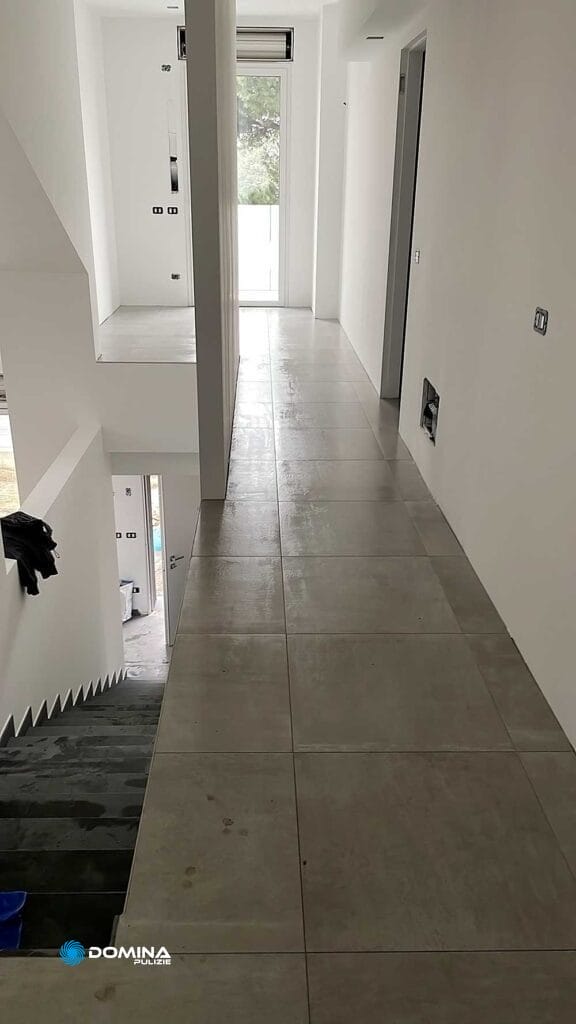 Una casa con pavimento piastrellato bianco e scale.