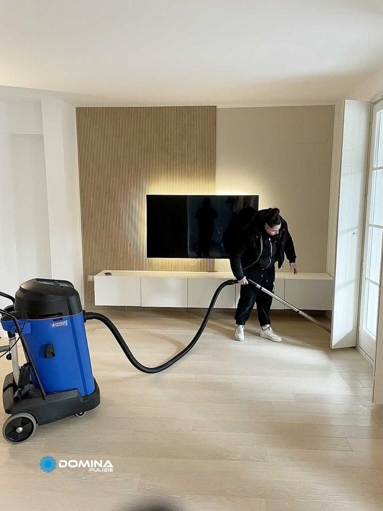 Un uomo che pulisce il soggiorno con l'aspirapolvere.