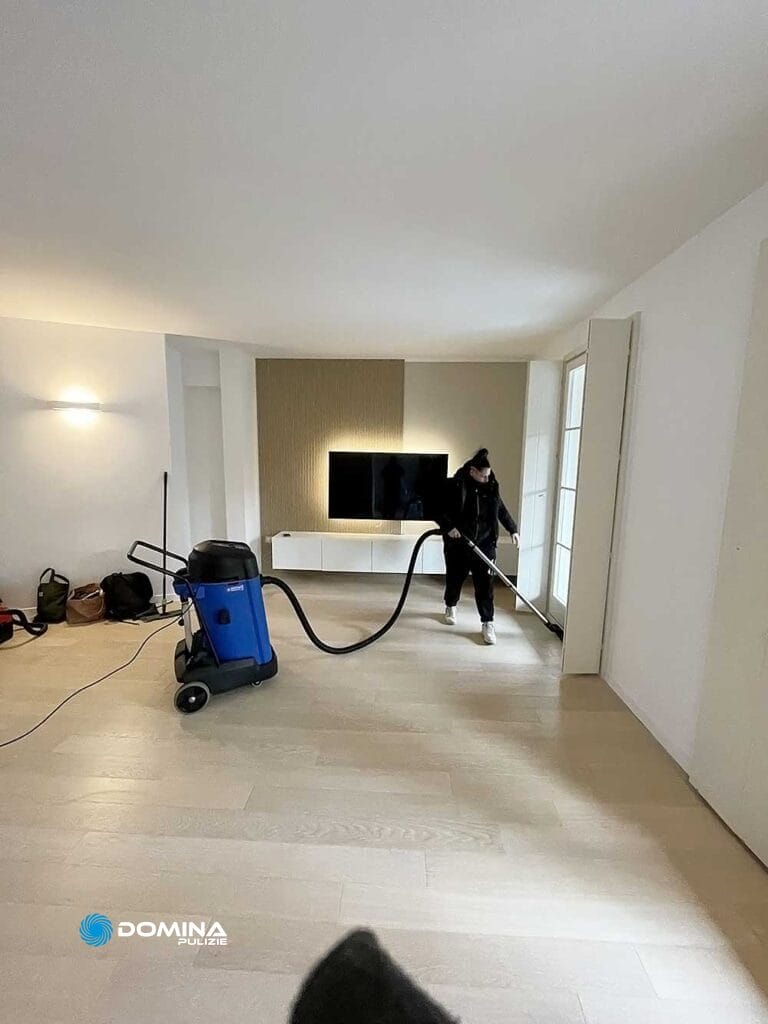 Un uomo sta pulendo una stanza con l'aspirapolvere.