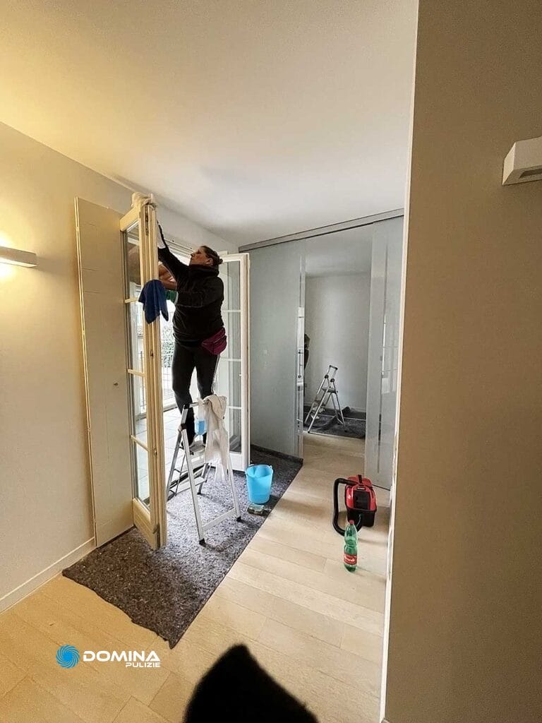 Una donna che pulisce una stanza con una scala.