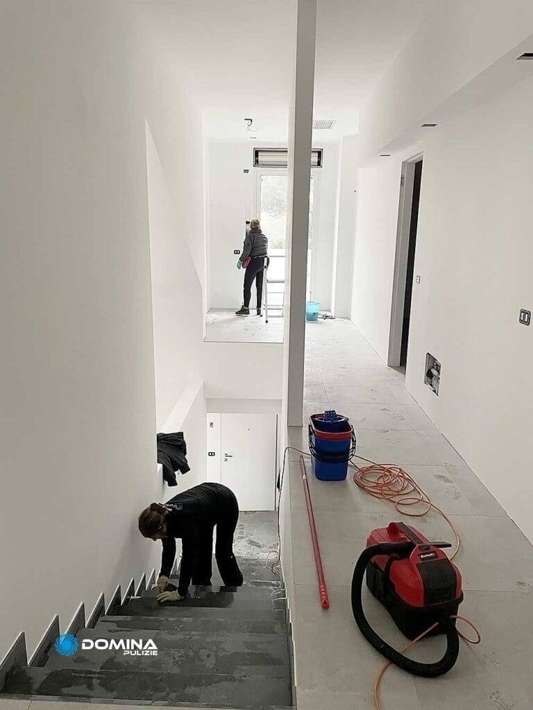 Due persone che lavorano sulle scale di una casa bianca.