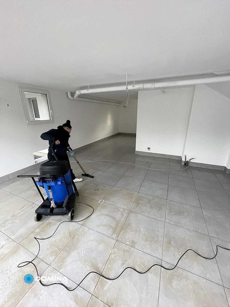 Un uomo che pulisce il pavimento di una stanza vuota.