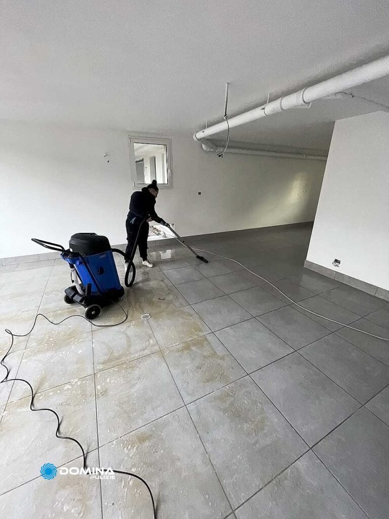 Un uomo che pulisce il pavimento piastrellato in un ufficio.