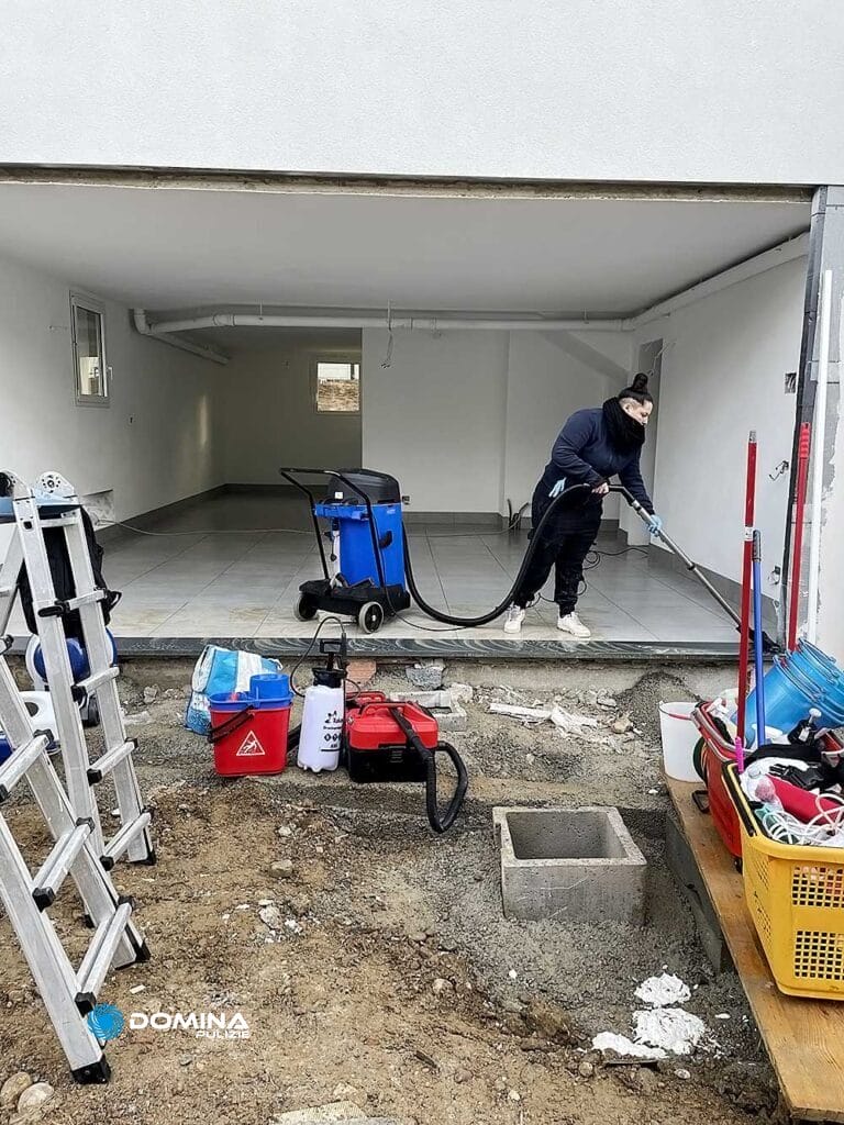 Un uomo che pulisce un garage con l'aspirapolvere.