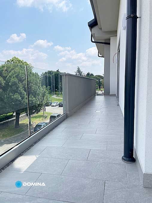 Un terrazzo con ringhiera in vetro dopo il servizio di pulizia di Domina Pulizie.