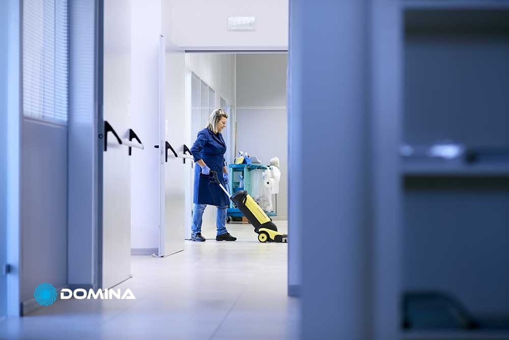 Donna di Domina Pulizie intenta a pulire un attività commerciale a Milano.