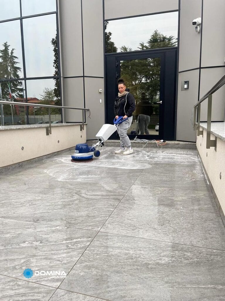 Un uomo pulisce il pavimento di un edificio.