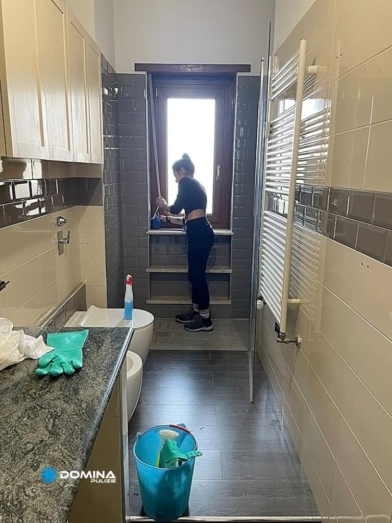 Una persona di Domina pulizie al lavoro per la pulizia di un bagno in un appartamento a Cernusco sul Naviglio.