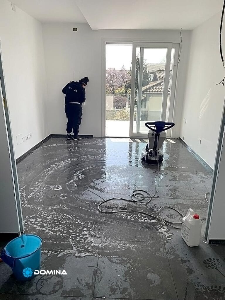 Una persona in piedi in una stanza con una macchina per le pulizie post ristrutturazione rescaldina.