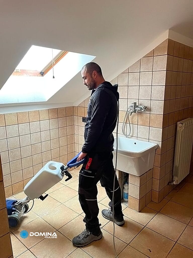 Un uomo utilizza attrezzature per la verniciatura per ristrutturare un bagno per le pulizie post ristrutturazione Senago.