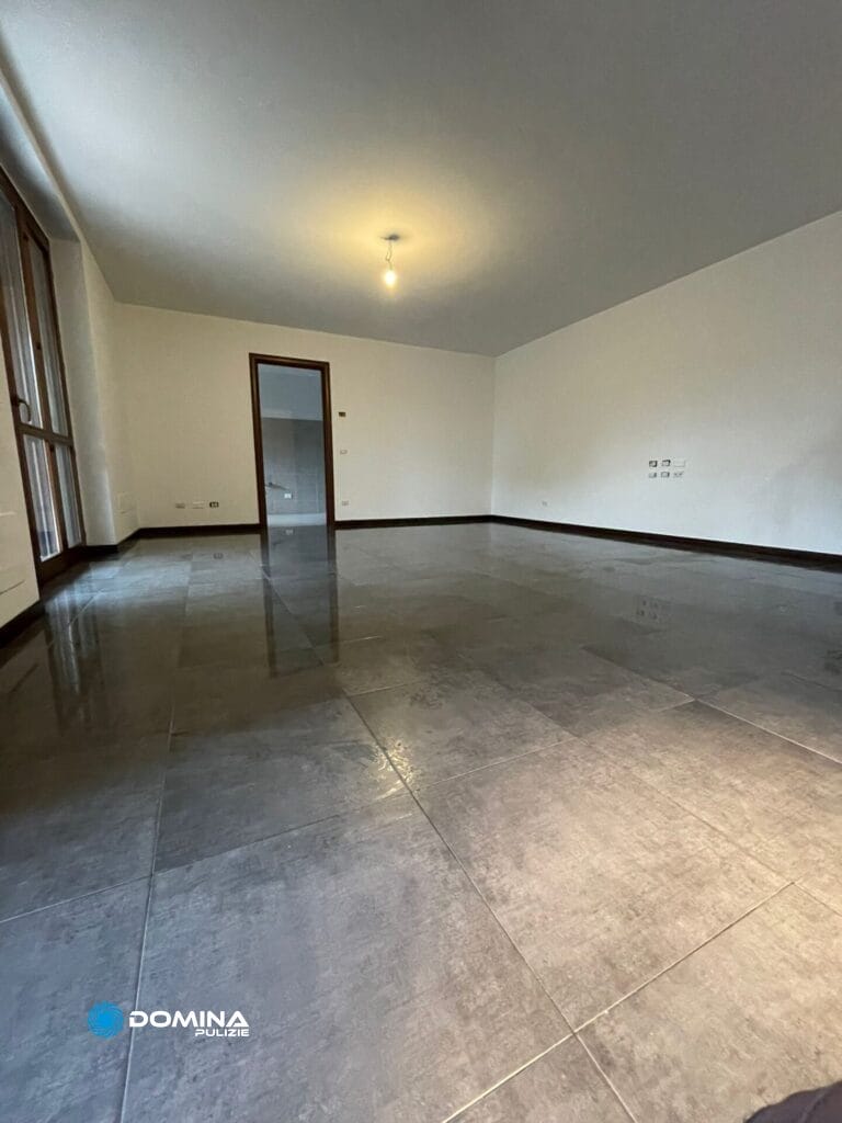 Una casa con una stanza dotata di pavimento piastrellato e una porta.