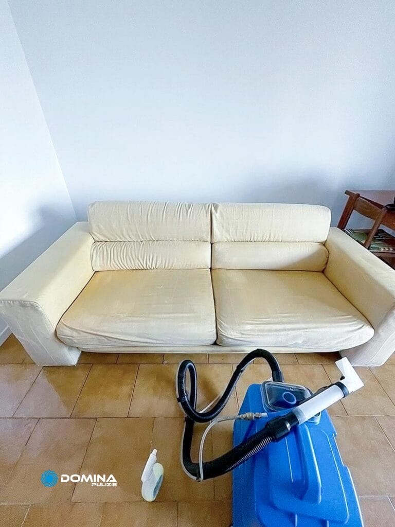 Un divano color crema in una stanza con in primo piano un macchinario per il Lavaggio Divani Saronno.