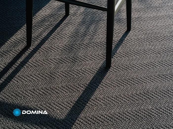 Le gambe della sedia proiettano ombre su una Moquette strutturata.