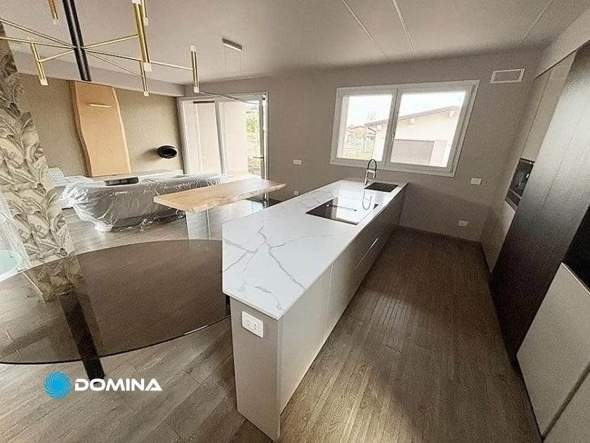 Situata nel cuore di Milano, questa cucina moderna vanta un'isola in marmo bianco ed elettrodomestici da incasso. La zona pranzo è dotata di ampie finestre e di un tavolo rotondo in vetro. I pavimenti in legno chiaro completano la carta da parati a motivi, rinnovando perfettamente il lusso con ogni dettaglio.