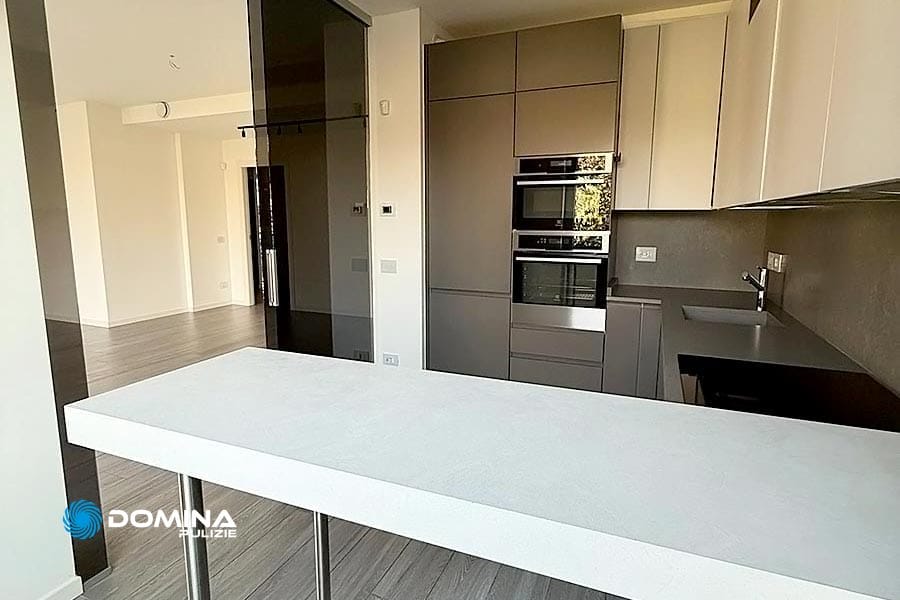 Cucina moderna con mobili eleganti, forno incorporato e un bancone minimalista. Toni neutri e superfici lisce dominano lo spazio, ideale per pulizie di lusso City Life Milano per mantenere il suo aspetto immacolato.