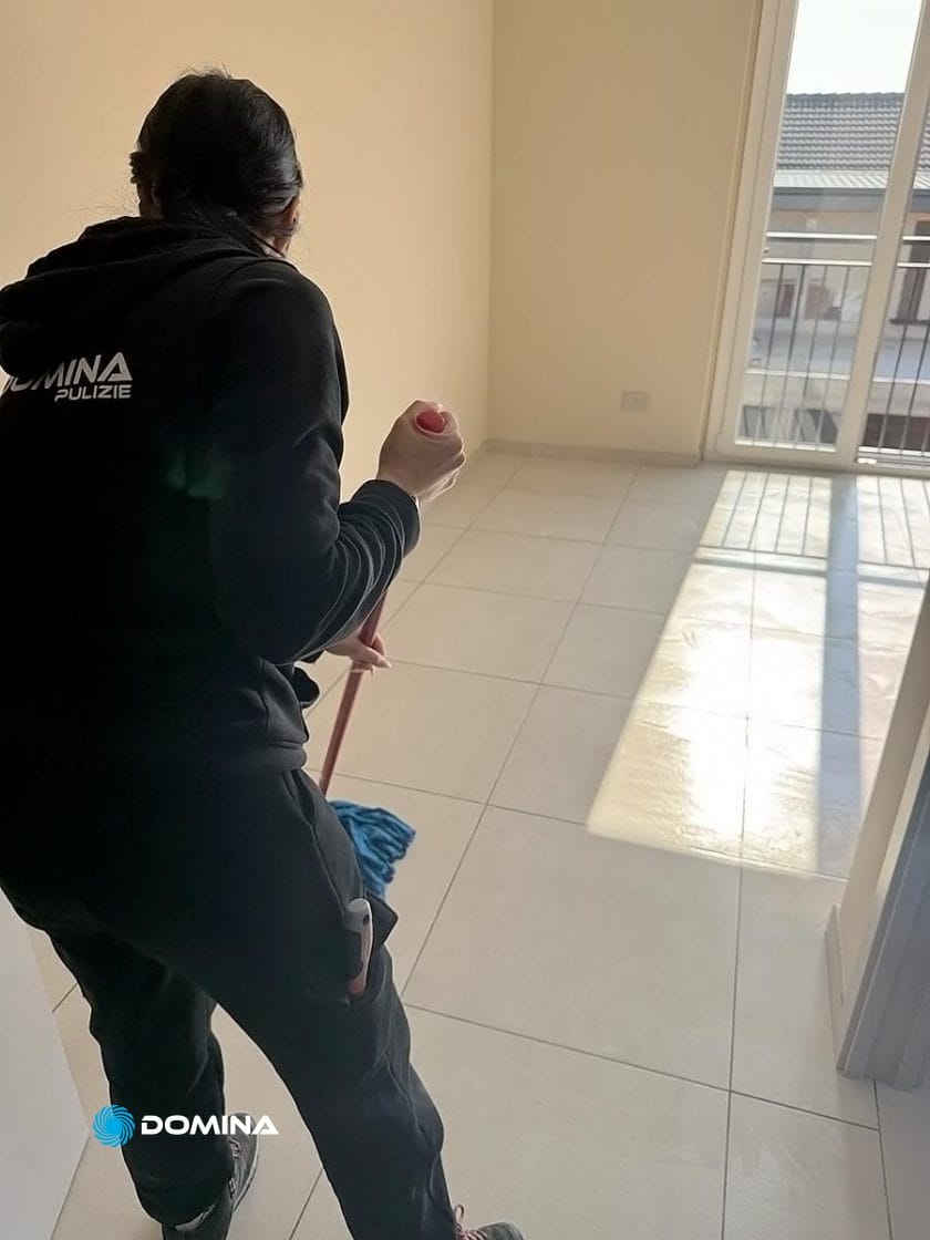 In una stanza illuminata dal sole, trasformata come quelle degli eleganti appartamenti di Mariano Comense, qualcuno sta diligentemente lavando il pavimento piastrellato. Attraverso la porta aperta, un balcone accenna a una tranquillità che va oltre le recenti attività di Pulizie Post Cantiere.