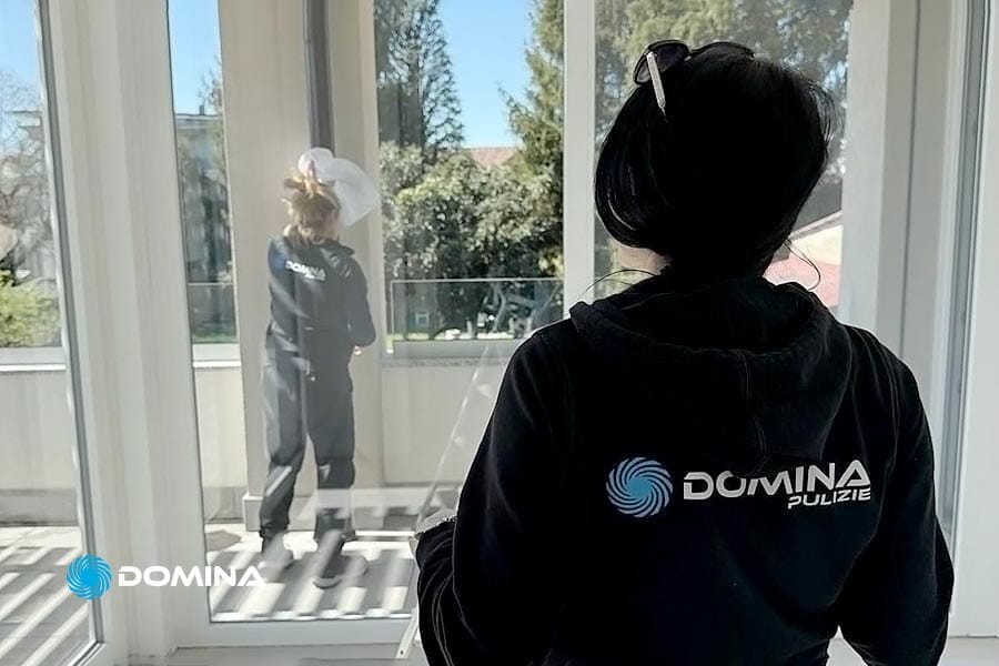Due persone del team di Domina Pulizie intente nella pulizia professionale di un terrazzo a Milano.