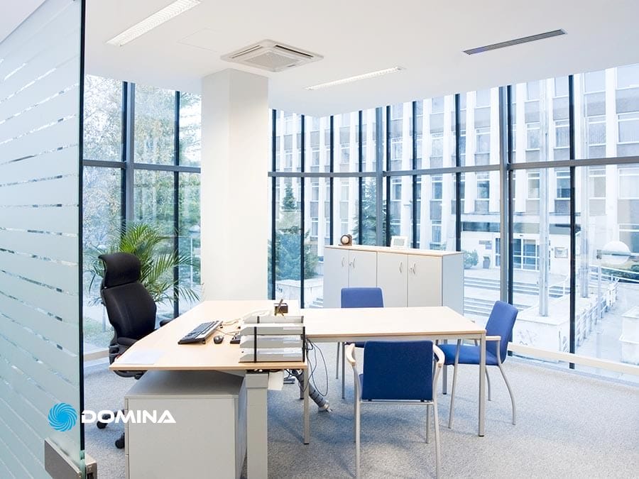 pulizie-uffici-1 Luminoso ufficio moderno a Garbagnate Milanese con scrivania, sedie, armadi e ampie finestre con vista su un edificio; ideale per Pulizie Uffici e aziende di Comuni Limitrofi che cercano uno spazio di lavoro accogliente.