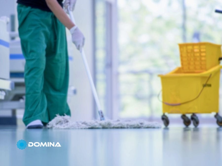 pulizie-uffici-4 Una persona che lava il pavimento vicino a un carrello delle pulizie giallo in un ambiente interno luminoso: perfetto per Pulizie Uffici a Garbagnate Milanese o Comuni Limitrofi.